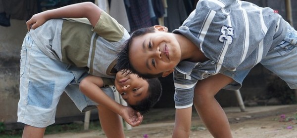 Two young boys acting silly in a street scene.