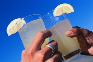 Two glasses of lemonade being clinked in celebration.
