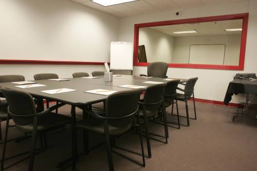 A focus group discussion room; the mirror framed in red hides a viewing room